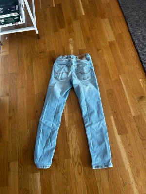 Ljusblå slim fit jeans - Snygga ljusblå jeans med slim fit passform och klassisk femficksdesign. Jeansen har en något tvättad look och raka ben. Perfekta för en avslappnad och trendig stil.