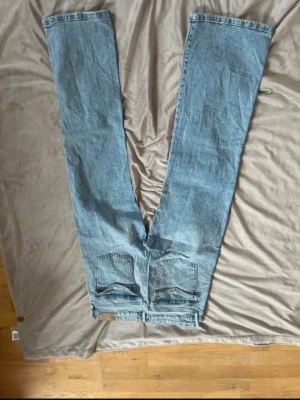 Ljusblå raka jeans - Säljer ett par ljusblå jeans med rak passform och klassiska fem fickor. Jeansen har normal midja och är tillverkade i denim med en snygg tvätt. Perfekta för en avslappnad och trendig stil.