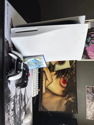 PlayStation 5 med DualSense och spel - Säljer en PlayStation 5 med vit och svart design, tillhörande DualSense-kontroll samt ett PS5-spel. Konsolen har en futuristisk look med rundade kanter och är tillverkad i plast. Perfekt för gaming och next-gen upplevelser.