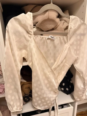 PRICKIG BLUS - Långärmad prickig blus supersöt!! Man knyter den som en omlotttopp och funkar att ha ensam eller med något under🥰🥰💋Sitter mer som en S men står M