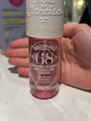 Sol de Janeiro Cheirosa 68 parfymmist - Fräsch parfymmist från Sol de Janeiro i doften Cheirosa 68. Flaskan är cylinderformad och genomskinlig med rosa vätska och vit spraykork. Doften har inslag av brasiliansk jasmin och rosa drakfrukt. Perfekt för dig som gillar fruktiga och blommiga toner. Köpt för 250 kr och är i nyskick, rymmer 90 ml