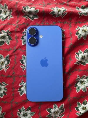 Blå iPhone 16 med dubbla kameror - Snygg blå iPhone 16 med stilren design och två stora kameror på baksidan. Telefonen har en platt framsida med tunn ram och en modern look. Tillverkad i glas och aluminium, perfekt för dig som gillar Apple och vill ha en färgglad mobil.