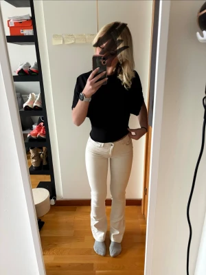 Vita bootcut jeans från ONLY - Säljer ett par vita bootcut jeans från ONLY med klassisk femficksmodell och normalhög midja. Jeansen har en snygg utsvängd passform och är tillverkade i ett stretchigt bomullsmaterial för extra komfort. Perfekta för en trendig och avslappnad look.