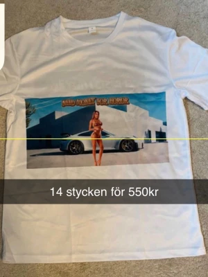 Vit t-shirt med tryck och text - Priset går att diskuteras!    Vit t-shirt med färgglatt tryck framtill som visar en bil och en person samt texten 'NEED MONEY FOR HOROR'. Baksidan har svartvit text med humoristiskt budskap. Klassisk passform och rund halsringning.