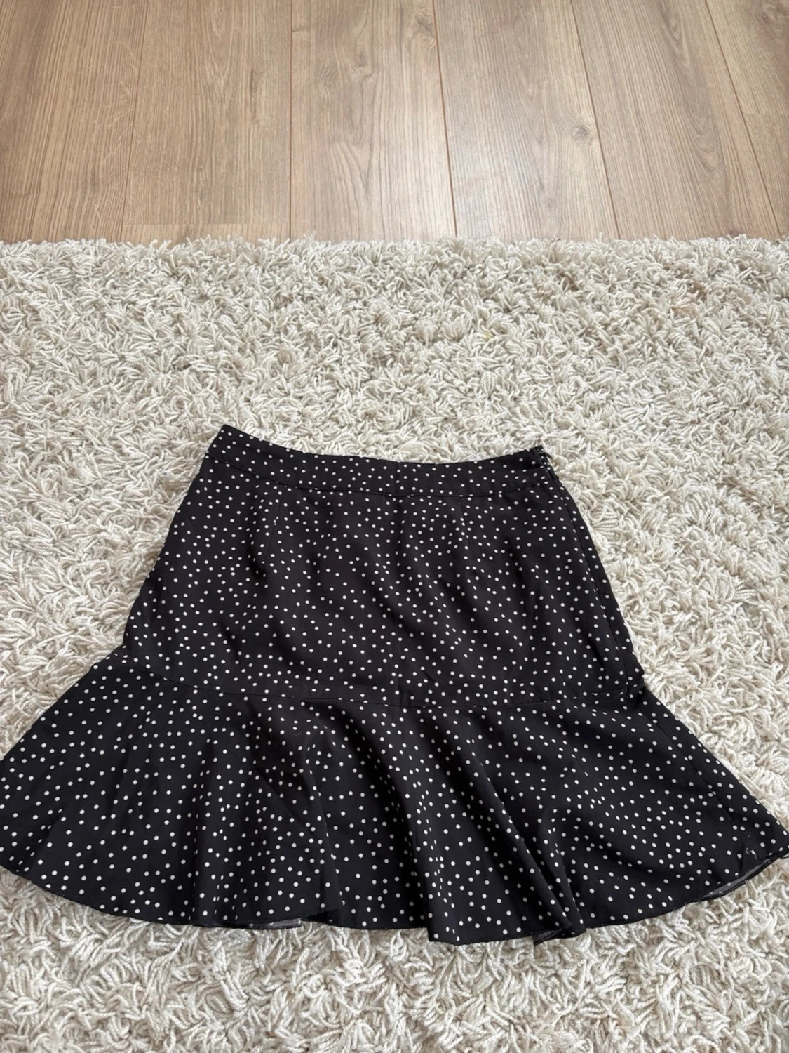 Svart prickig kortkjol med dragkedja