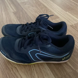 Blåa spikskor! - Säljer ett par blåa spikskor från decathlon! Väldigt bra skick använda få gången pga för små du får även med dig en påse till spikskorna och ett ”verktyg” att skruva åt spikarna! Säljer för 150.