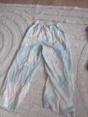 Pastellfärgade vida linnebyxor - Säljer ett par lösa och bekväma linnebyxor i pastellfärger med bred resår i midjan. Perfekta för en avslappnad och trendig look. Ord pris 350kr