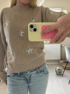 Beige stickad tröja med silverstjärnor - Beige stickad tröja med stjärnor framtill! Storlek 158/164 men passar mig som vanligtvis har xs💕 Pris kan diskuteras! Hör av er om ni har några funderingar💓