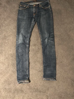 Blå slim fit jeans från Nudie Jeans - Säljer ett par blå slim fit jeans från Nudie Jeans.