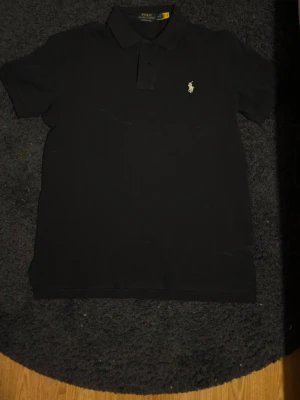 Mörkblå Ralph Lauren pike - Säljer denna SPRILLANS NYA Ralph pike i storlek M, dock utan tags men helt oanvänd. QR koden skannar till hemsidan, hör av vid minsta fundering