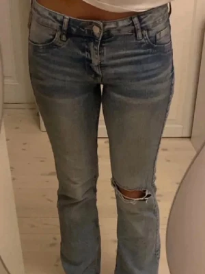 Ljusblå low waist bootcut jeans - Säljer ett par lågmidjade ljusblå jeans från HM som ej längre säljs, endast använts någon gång och är i bra skick, storlek 34! ❗️Du står för frakten❗️