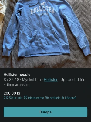 Blå hoodie från Hollister - Snygg ljusblå hoodie från Hollister med vit broderad logga och texten 'California' på bröstet. Klassisk känguruficka framtill och huva med dragsko. Perfekt för en avslappnad och cool stil.