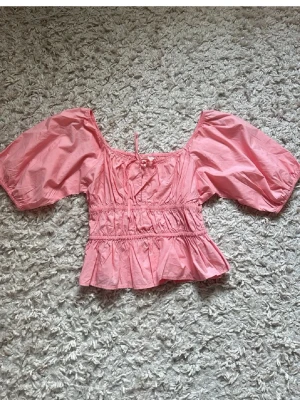 Rosa croppad topp med puffärmar - Söt rosa croppad topp med volangkant och puffiga korta ärmar.  Den är lite kort ändå, men verkligen så vacker till sommar 💕