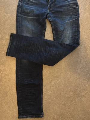 Mörkblå Dressmann jeans - Stilrena mörkblåa/rawdenim jeans från dressman, storlek 34/32.
