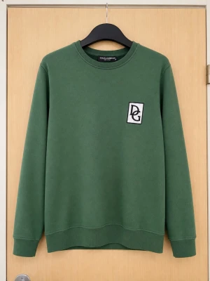 Grön sweatshirt från Dolce & Gabbana - Snygg grön sweatshirt från Dolce & Gabbana med DG-logga på bröstet. Tröjan har rund halsringning och ribbade muddar vid ärmslut och nederkant. Tillverkad i mjukt material som känns skönt mot huden. Perfekt för en avslappnad och trendig look.