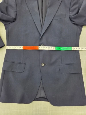 Oscar Jacobson slim kostym m väst & skjorta - Modern mörkblå slimfit kostym i ull/polyester/elastan. Hel och ren. Fler bilder med ytterligare mått på gren, midja mm på byxa och väst finns. Storlek 46 på kavaj och byxa, storlek 44 på väst och storlek 38 på slim fit skjorta. Byxa grenlängd 77 cm + 3 cm att lägga ner, midja 42 cm. Hör av dig om du vill se fler bilder. Kan skickas.