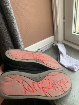 Svarta loafers från Christian Louboutin - Säljer ett par svarta loafers från Christian Louboutin med den ikoniska röda sulan och logotypen undertill. Skorna har en klassisk och stilren design i svart tyg och passar perfekt för dig som vill sticka ut med exklusiva detaljer. Kan tvättas vis köp!