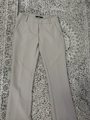 Lågmidjade beige kostymbyxa från bikbok - Lågmidjade beige kostymbyxor från bikbok i storlek 34 använda få par gånger i nyskick