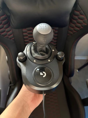 Logitech växelspak till racingratt - Säljer en svart Logitech växelspak för racingratt, perfekt till simracing. Den har en rund växelspaksknopp i plast och konstläder, med sex växellägen och robust design. Passar till Logitech G-seriens rattar och kopplas in med kabel.
