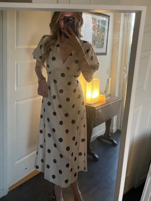 Prickig midiklänning - Prickig midiklänning i strl S. har snörning i midjan och kan därför justeras efter önskemål. Ej använd. Köpt för 1240kr