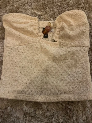 Beige bandeau topp med pärldetalj - Fin beige topp med pärldetalj 