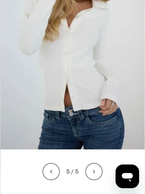 Vit ribbad skjorta med knappar - Snygg vit skjorta med ribbad struktur och klassisk krage. Skjortan har långa ärmar och stängs med knappar framtill. Aldrig använd. Ny pris 299kr säljs inte mer.