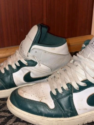 Air Jordan 1 Mid  - Säljer ett par Nike Air Jordan 1 Mid sneakers i grön och vit färg. Storlek 41 EU. Använda 5 gånger. NYSKICK!!! 