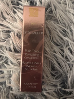 Estée Lauder Pure Color Crystal Balm - Säljer ett Estée Lauder Pure Color Revitalizing Crystal Balm. Förpackningen är elegant i roséguld och innehåller 3,2g läppbalsam som ger färg och återfuktar läpparna. Perfekt för dig som vill ha både vård och en hint av färg.