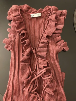 Ribbad volangtopp från Zara  - Supersöt vinröd ribbad topp från Zara, den har ett litet hål på volangen men syns knappast, den ser helt ny ut annars🩷