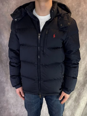 Marinblå Ralph Lauren Jacka - Stl M - RIKTIGT FET RALPH LAUREN JACKA! Mycket bra skick: 9/10, liten lagning på höger ärm, (går att få med en marinblå lagningslapp om man önskar) | Stl: M, Modellen är 175cm och väger ca 77kg, och sitter bra! | Hör av dig vid frågor // Galgen 🫡