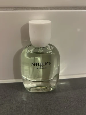 Zara Applejuice parfym - Fräsch parfym från Zara med namnet Applejuice. Flaskan är rundad och genomskinlig med vit kork och svart text. Doften är en del av Day Collection och har en ljusgrön ton på vätskan. Perfekt för dig som gillar fruktiga och lätta dofter.