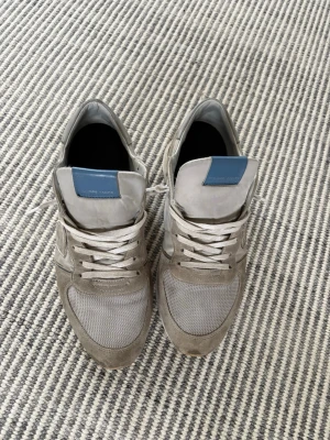 Philippe Model  - Snygga sneakers från Philippe Model i grått mocka och mesh. Skorna har vita snören, blå detalj på plösen och klassisk låg siluett. Perfekta för dig som gillar stilrena och bekväma sneakers med exklusiv känsla. Box ingår tyvärr inte pris kan diskuteras vid snabb affär 🍾