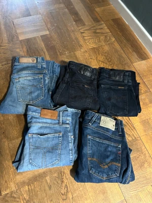 BULK! Fem par jeans replay,nudie och tiger of Sweden  - Bulk 2 par tiger of seden jeans, 1 par replay och 2 nudie, sjukt bra pris perfekt för resell! fem par jeans i olika blå och svarta nyanser. Modellerna varierar mellan slim och regular fit, med klassiska femficksdetaljer och kontrastsömmar. Några har läderpatch på linningen och synliga märkesloggor. Perfekta för dig som vill ha flera stilar att välja mellan. Storlekar 29-32