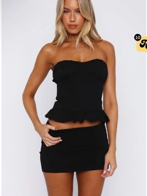 Svart bandeau korsett topp med volang - Säljer en svart bandeau korsett topp med volangdetalj nedtill. Toppen är från white fox i storlek xs, säljer då den var för liten för mig.