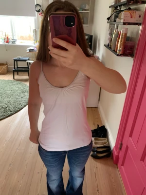 Vit enkel linnetopp med smala band - Säljer en vit linnetopp med smala axelband och lätt rynkad ringning fram. Toppen har en figurnära passform och är perfekt till jeans eller kjol. Materialet känns mjukt och stretchigt, troligen bomull eller en bomullsblandning. Står storlek S på lappen, men passar storlek M och S. 