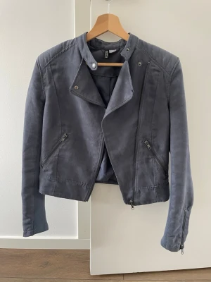 Blå jacka i mockaimitation från  H&M - Snygg blå bikerinspirerad jacka i mockaimitation från H&M med asymmetrisk dragkedja, två snedställda fickor med dragkedja. 