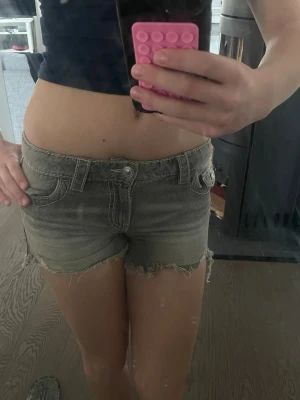 Grå jeansshorts - Säljer ett par grå jeansshorts med slitna detaljer och fransig kant. Säljer då de inte kommer till användning.