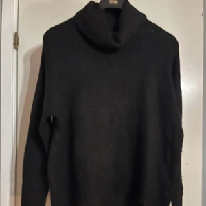 2 st stickade svarta tröjor - Mysig svart stickad polotröja med lång ärm och avslappnad passform. Tröjan har en hög polokrage och är perfekt för kyliga dagar. Enkel och stilren design utan synliga detaljer eller mönster. Andra tröjan är lite mer finstickad och båtringad 
