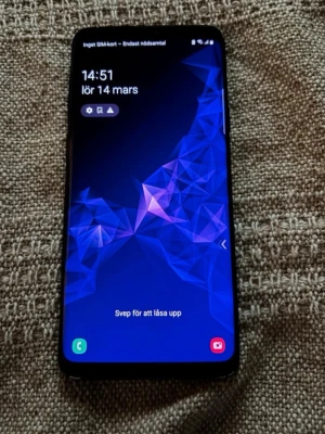 Samsung Galaxy S9+ DUOS - Samsung Galaxy S9 Plus smartphone i svart färg. Telefonen har stor skärm med tunn ram och dubbla kameror på baksidan samt blixt. Modellen på bilderna är en Duos‑variant med plats för två SIM‑kort. Lämplig för vardaglig användning som samtal, meddelanden, surf, appar och mediauppspelning.  Finns tecken på användning kring ramen samt små märken/repor på skärmen och baksidan men gott skick överlag samt en liten spricka i övre högra hörnet men inget som påverkar!
