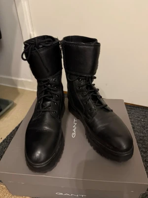 Svarta läderkängor från Gant - Snygga svarta kängor från Mango i troligtvis äkta läder då de var dyra i inköp med snörning framtill och dubbla spännen baktill. Grov sula för extra grepp och cool look. Perfekta för vår och höst när du vill ha både stil och funktion. Smal passform. 