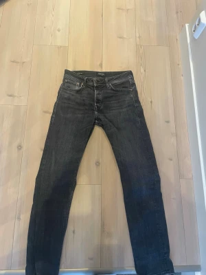 Svarta raka jeans från Jack and Jones  - Säljer ett par svarta jeans från Jack and Jones med rak passform och klassisk femficksdesign. Jeansen har diskreta sömmar och är tillverkade i denim med en lätt tvättad look. Perfekta för en avslappnad och stilren outfit.