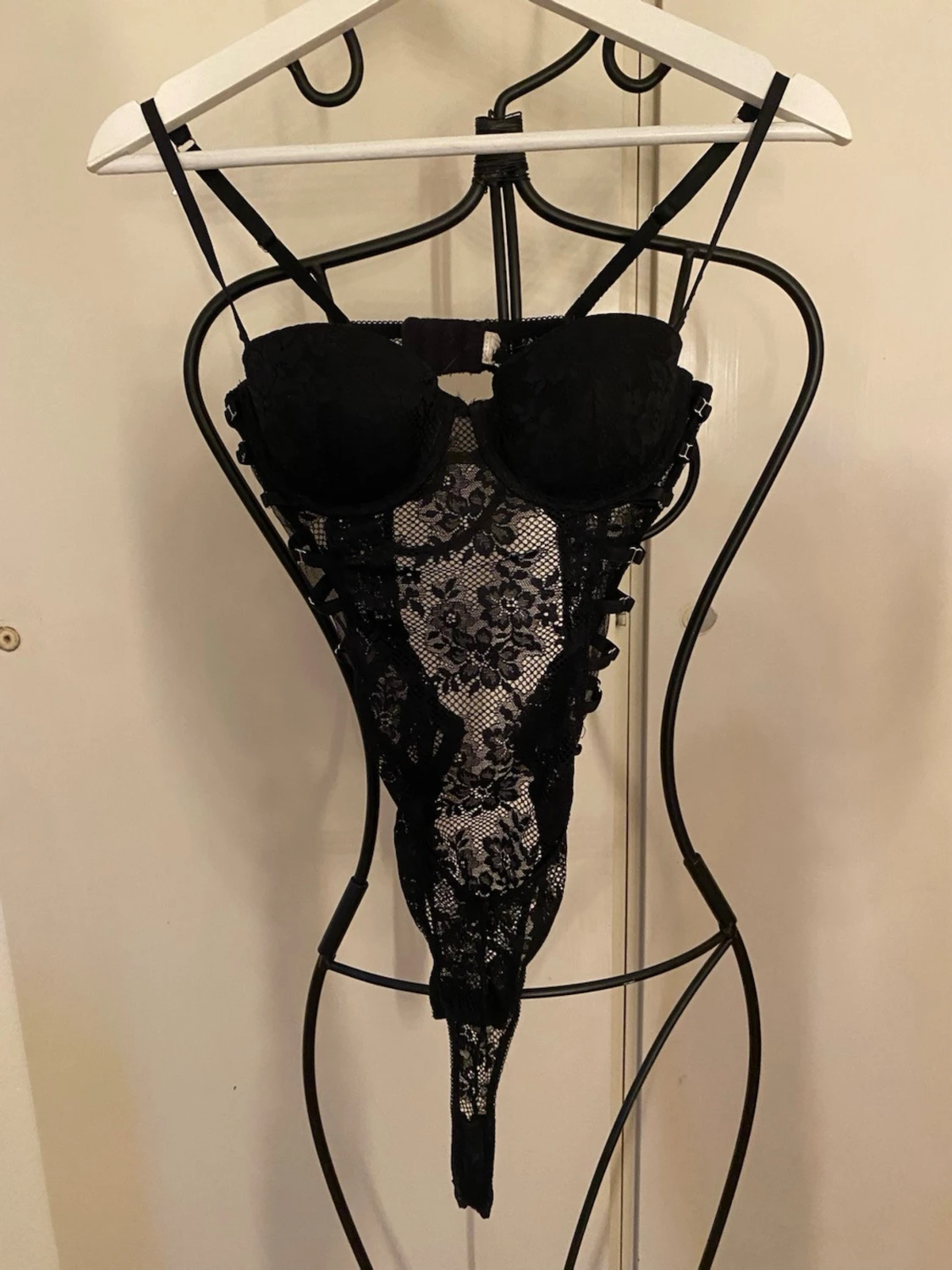 Svart spetsbody med banddetaljer och öppen rygg