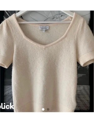 Ljus stickad topp från &Other stories  - Superfin ljus stickad topp från & other stories med korta ärmar och v-ringad hals. Mjuk och skön kvalitet som känns lyxig, perfekt till jeans eller kjol. Ribbad kant nedtill och vid ärmslut för en snygg passform.