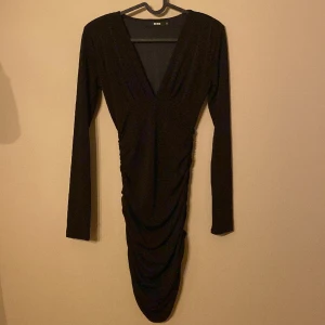 Svart festklänning - Super snygg svart klänning med djup v-ringning! En svart klänning i nytt top skick! Vadd i axlarna  vilket gör att klänningen bli riktigt elegant! Super fin klänning! Inget slitage!  Passar XS och S! Perfekta klänningen!😍