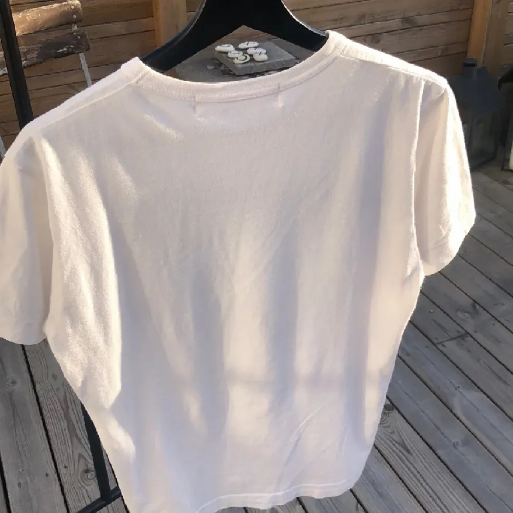 En vit t-shirt med text. Köptes för 950kr på NK har använt den sällan men tagit hand om den. Den är 8.5/10 i skick.  Strlk S men passar även XS. T-shirts.