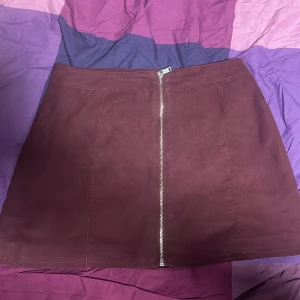 Dragkedja kjol - Väldigt fin kjol, man kan använda den formellt eller vardagligt. Har endast använt ett par gånger(1-2). Färgen är vinröd. Storlek: M