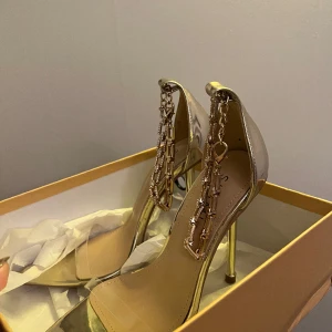 Klackar - Helt nya klackskor i guld. Hög klack storlek 39. 