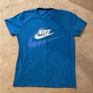 Det är en blå nike t-shirt med storleken Medium men passar även s storlek