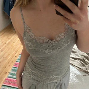 Spetslinne - Grått linne med spets, något nopprig men tycker inte det märks. Justerbara axelband. 