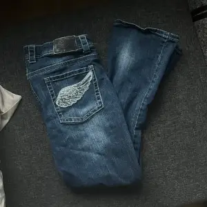 Jeans med fint tryck av vingar och rhinestones på bakfickorna. 